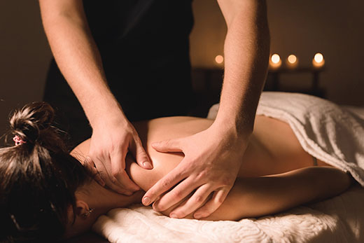 A woman receiving a relaxing back massage in a serene spa environment.