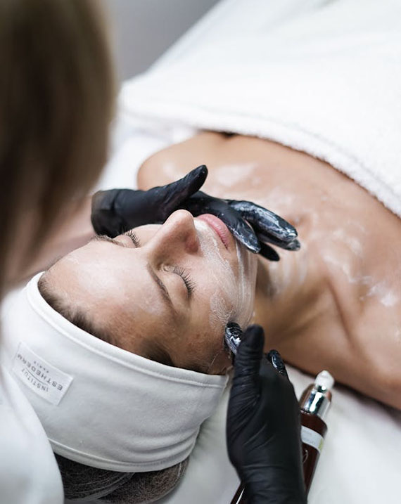 A woman receiving a facial treatment while relaxing in a serene spa environment.
