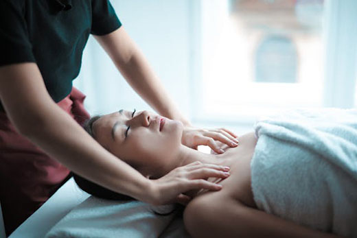 A woman receiving a relaxing massage in a serene spa environment.