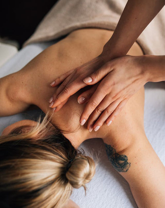 A woman receiving a soothing back massage in a serene spa setting.